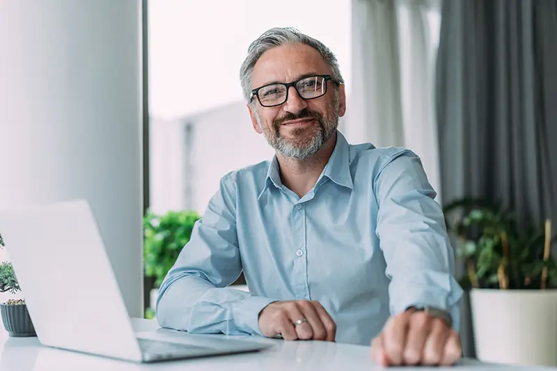 Image of a man looking directly into the camera, smiling with confidence